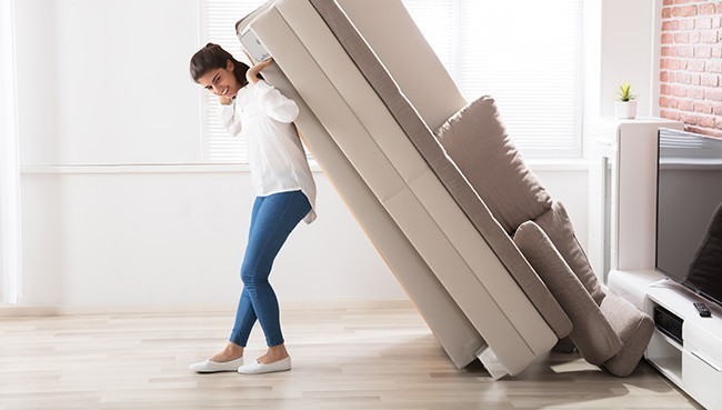 Woman moving sofa | LeClaire Flooring