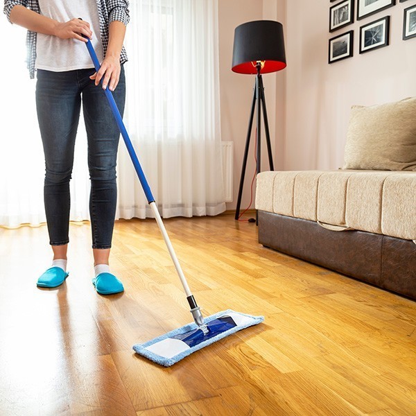 Woman cleaning laminate floor | LeClaire Flooring